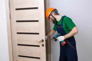 male locksmith installs door apartment guy works with screwdriver 1